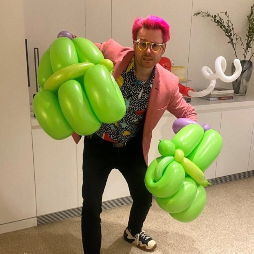 Dave Brenn wearing oversized green balloon hands performing balloon entertainment in New York and New Jersey.
