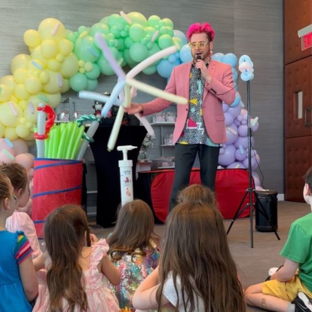 Dave Brenn performing a balloon entertainment show on stage for a group of kids in New York and New Jersey.