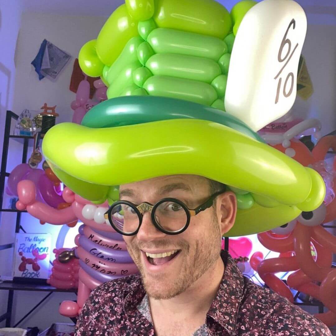 Dave Brenn wearing oversized green Mad Hatter balloon hat
